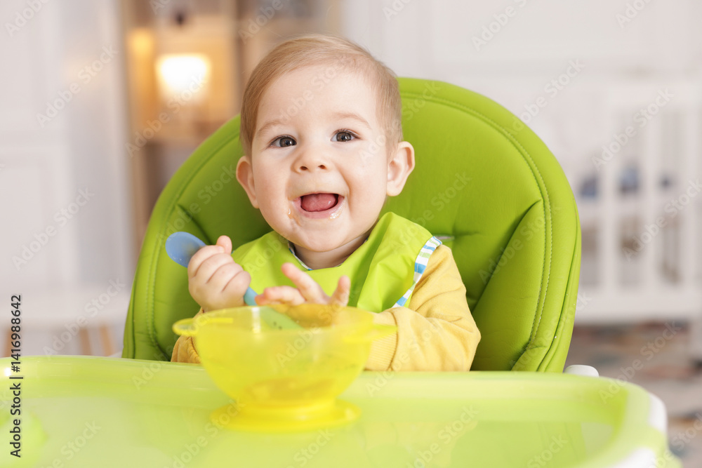 Cute little baby eating healthy food in high chair indoors Cute little baby eating healthy food in high chair indoors