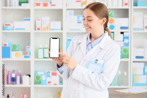 Female pharmacist with mobi...
