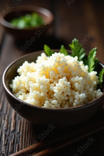 Obraz na płótnie A bowl of fluffy rice sits on a dark wooden table , wooden table, minimal, rice w salonie