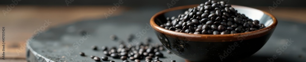Small ceramic bowl overflowing with black sesame seeds , food, ceramic bowl