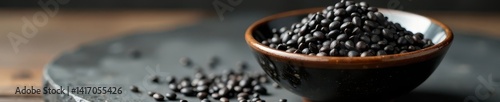 Small ceramic bowl overflowing with black sesame seeds , food, ceramic bowl