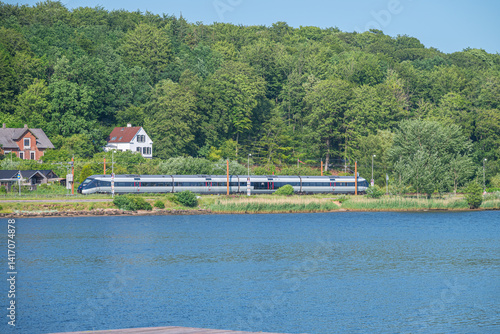 DSB IC4 train in the nature of Vejle fjord in Denmark