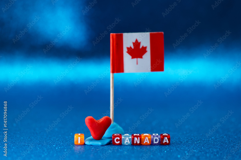 Creative display of a Canadian flag with love heart and letter blocks on blue background for celebrating Canadian pride and heritage
