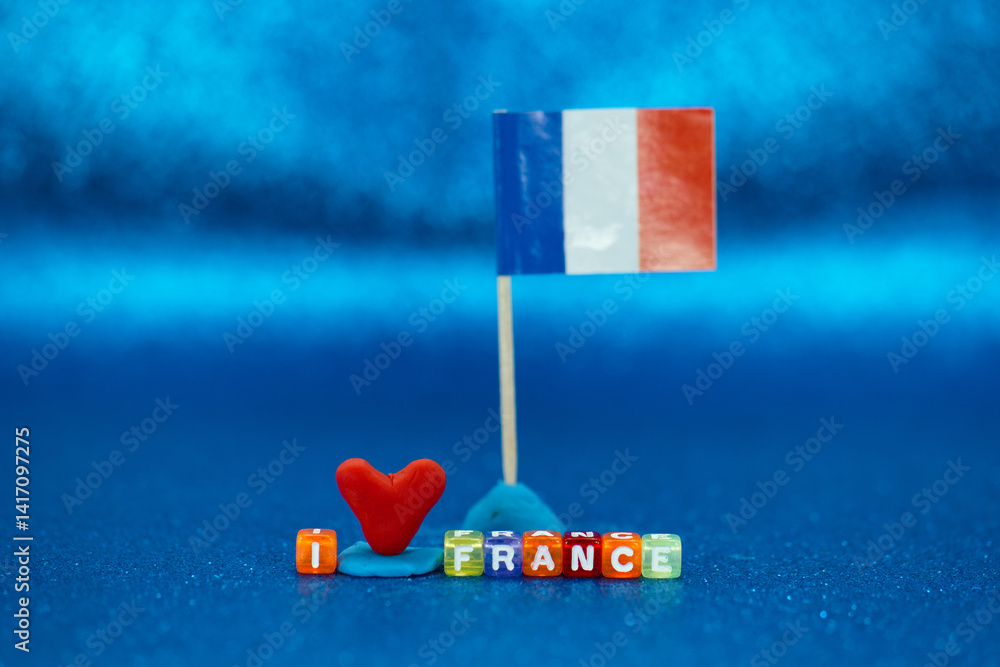 Creative display of love for France with colorful beads and a flag on a blue background