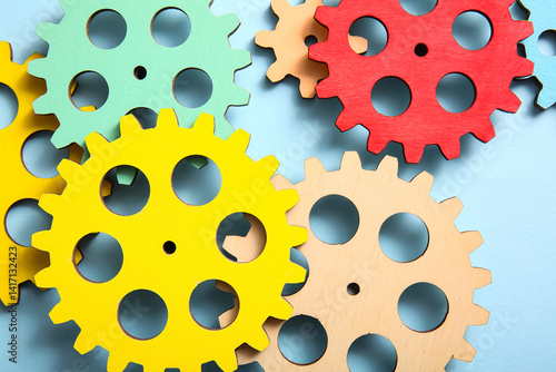 Wooden gears on light blue ...