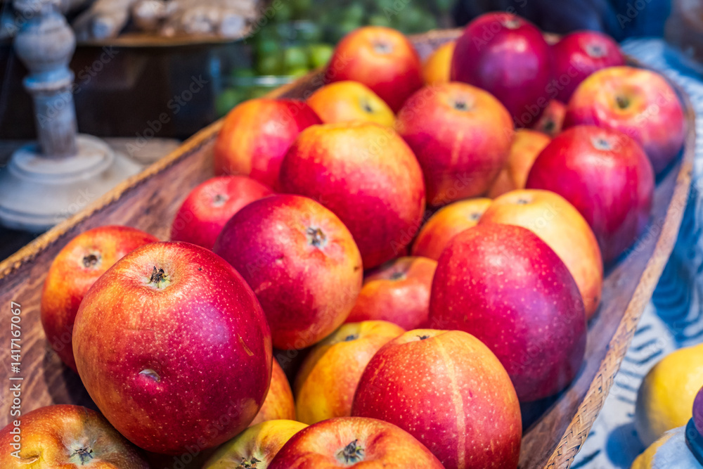 Freshly harvested apples displayed in a rustic basket at a local market during the autumn season with vibrant colors and natural lighting Freshly harvested apples displayed in a rustic basket at a local market during the autumn season with vibrant colors and natural lighting
