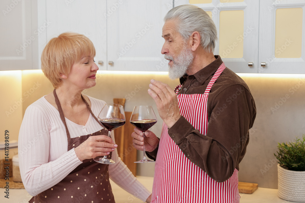 Senior couple with glasses of wine in kitchen Senior couple with glasses of wine in kitchen