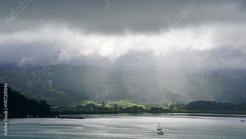 God rays shining on a dark and mysterious seaside cove with mystic mountains in the background