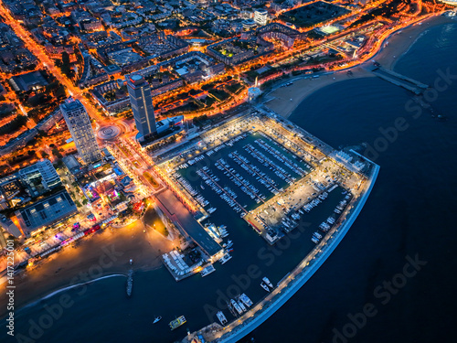 Photography Overhead night view of Port Olimpic marina and city lights along the beach