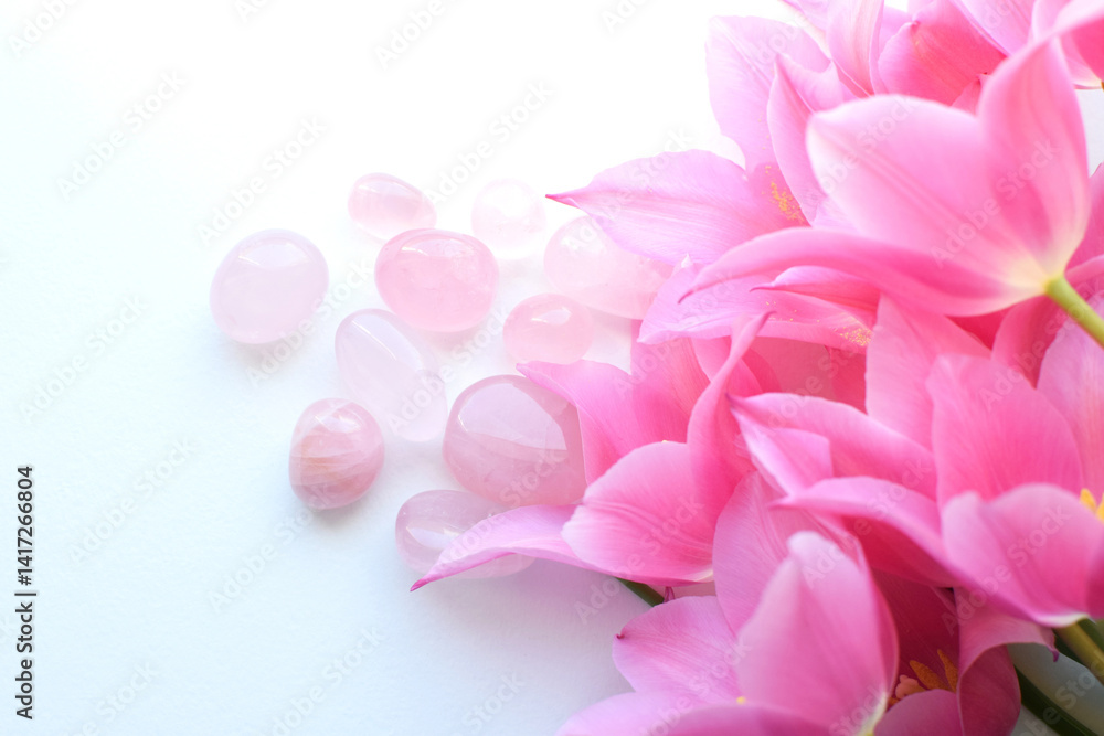 Naklejka premium Beautiful rose quartz crystals and a bouquet of pink tulips. Healing crystals, talisman for women