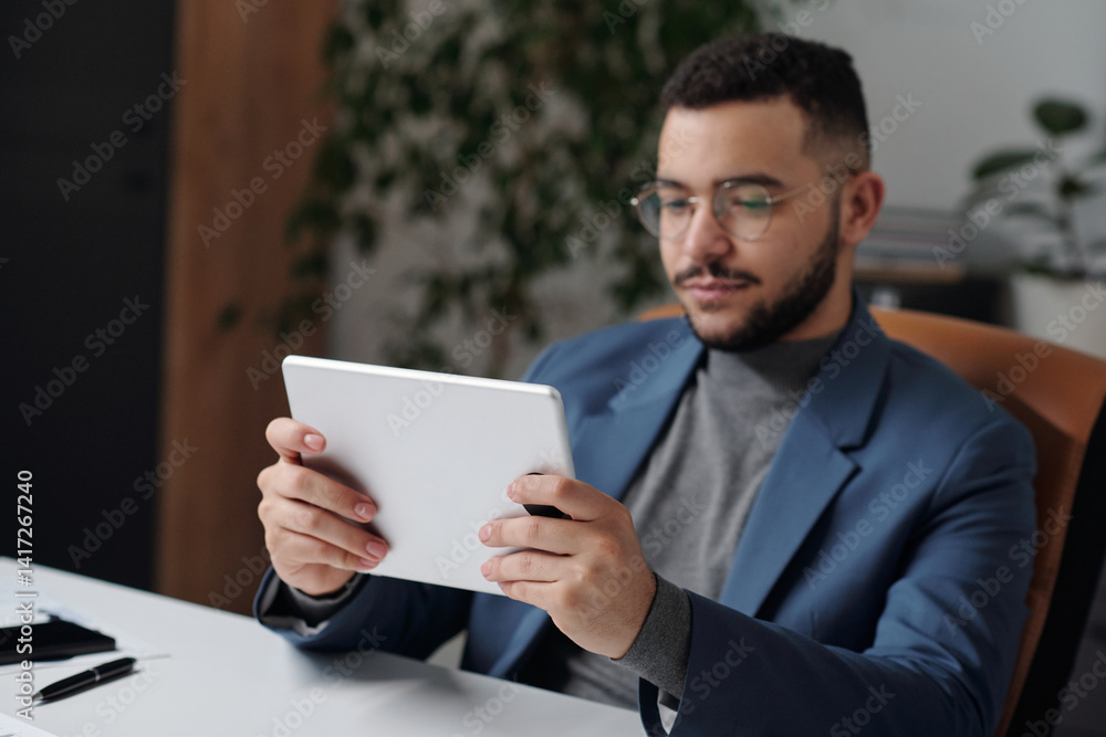 Portrait of businessman at workplace using digital tablet with focus on foreground copy space Portrait of businessman at workplace using digital tablet with focus on foreground copy space