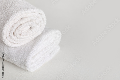 Rolled clean towels on light background