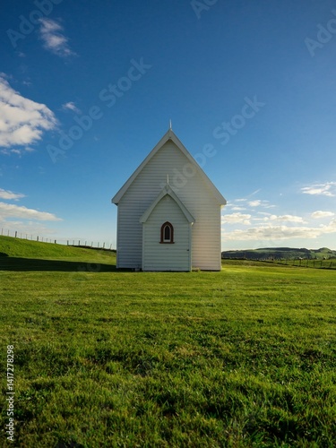 Idyllic iconic rural remote white presbyterian christian chapel Kohekohe Church on green grass meadow on Awhitu Peninsula near Auckland New Zealand