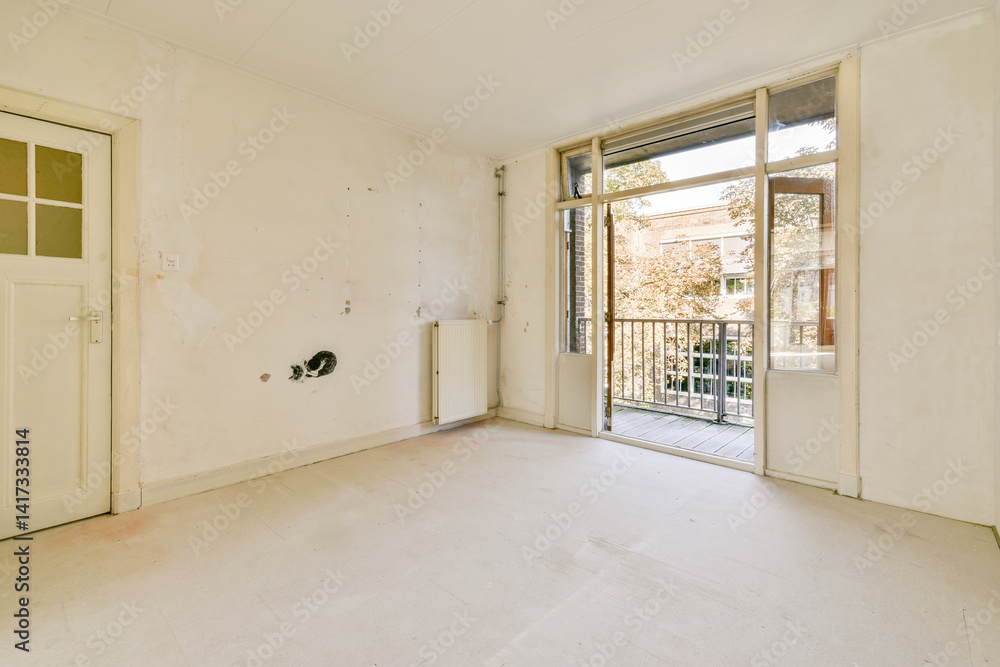 A vacant room featuring a large window that offers a view of outdoor greenery, illuminated by natural light. Ideal for renovation or interior design. A vacant room featuring a large window that offers a view of outdoor greenery, illuminated by natural light. Ideal for renovation or interior design.
