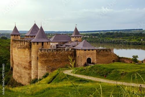 Majestic medieval Khotyn Fortress in Ukraine, with its stone walls and towers, overlooking the green landscape and river. Historical landmark.