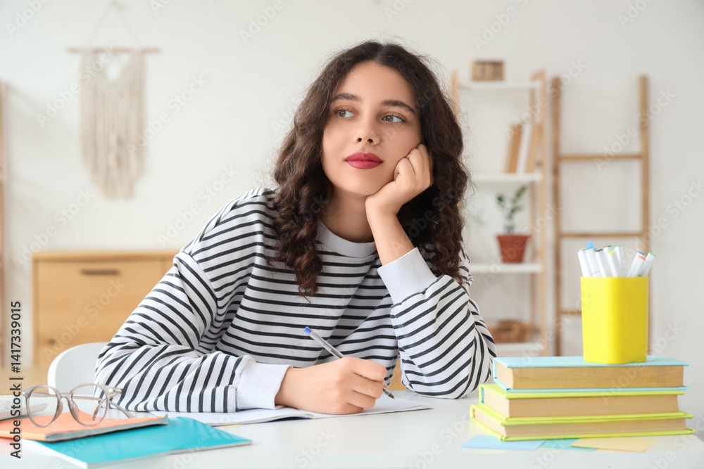Thoughtful female Indian student studying at home Thoughtful female Indian student studying at home