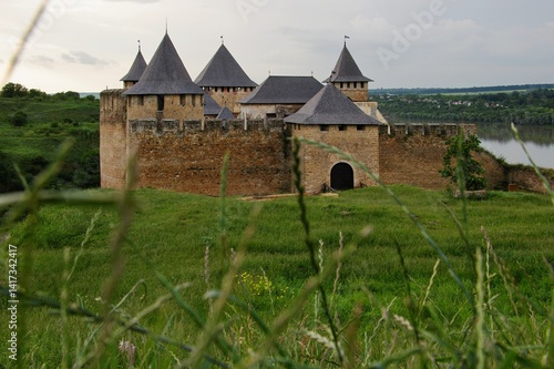 Majestic medieval Khotyn Fortress in Ukraine, with its stone walls and towers, overlooking the green landscape and river. Historical landmark.