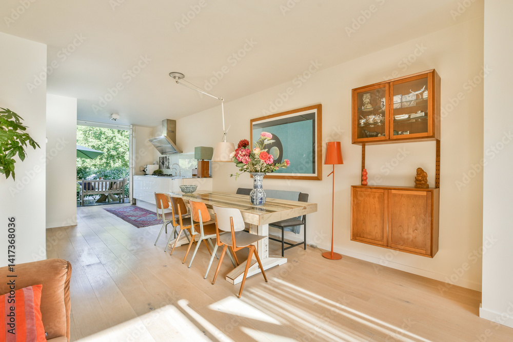 Fototapeta premium A bright and airy modern dining room featuring a wooden table, chairs, and stylish decor, perfect for gatherings and family meals.