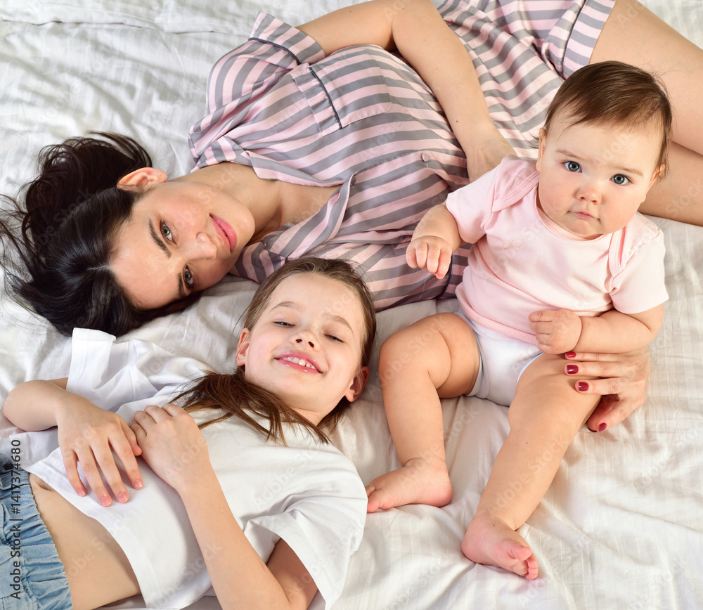 Mother and her daughters playing and smiling. Happy family.Home interior. Mother and her daughters playing and smiling. Happy family.Home interior.