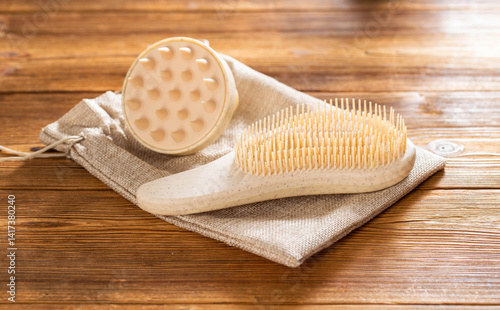 Obraz na płótnie Brown massage comb and scalp massager on wooden background, close-up