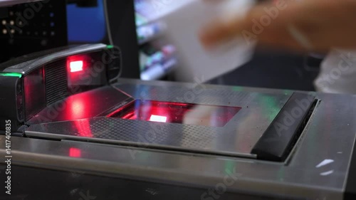 Shopper scanning groceries at self service kiosk, efficiently processing items using automated barcode technology in modern retail environment