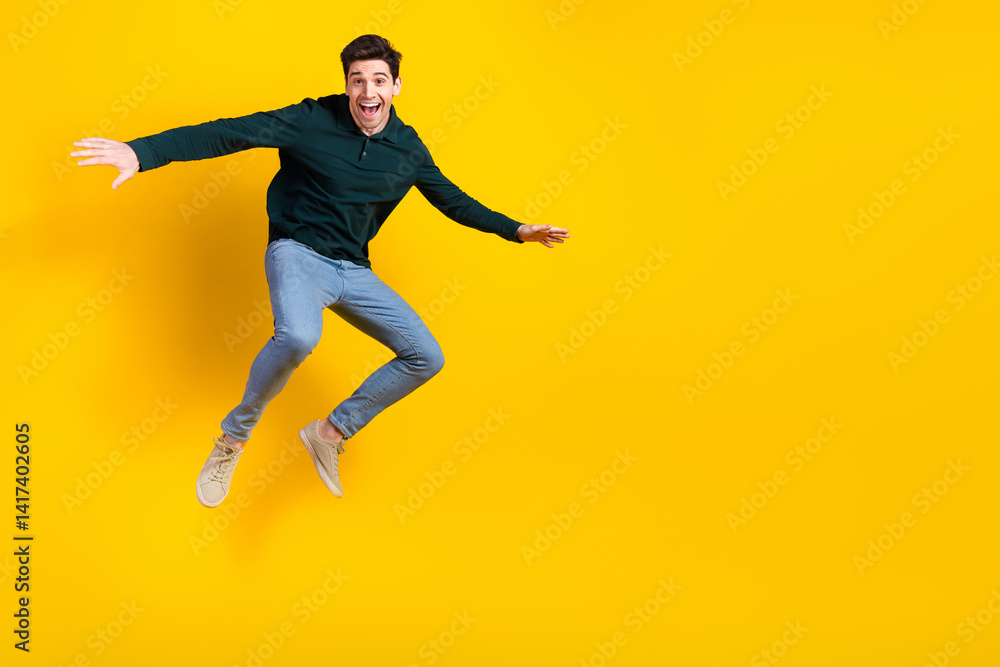 Cheerful young man in stylish casual wear posing joyfully against a vibrant yellow background, radiating happiness Cheerful young man in stylish casual wear posing joyfully against a vibrant yellow background, radiating happiness