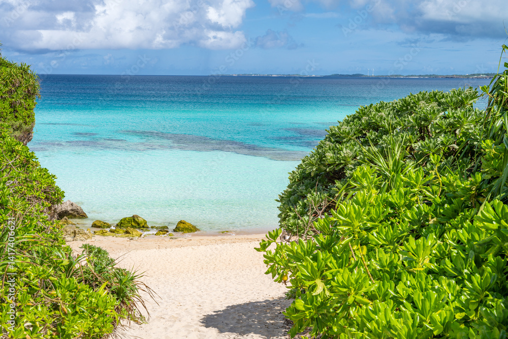 Lush greenery frames a pristine beach and turquoise waters in Okinawa, Japan
