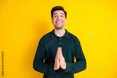 Billede på lærred Cheerful young man clasping hands together as a gesture of gratitude or plea aga