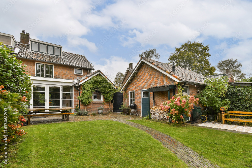 Obraz premium A picturesque residential scene featuring two cozy houses surrounded by lush greenery and a welcoming garden pathway. Perfect blend of nature and architecture.