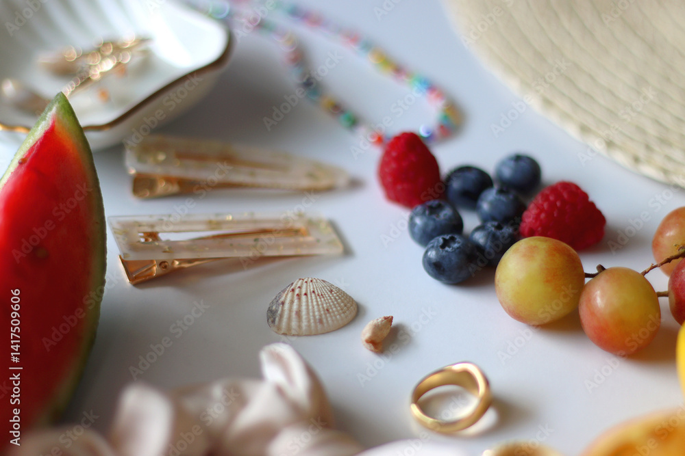 Straw hat, sunglasses, seasonal fruit, seashells and colorful accessories on white backgrounds. Cute summer essentials. Selective focus.