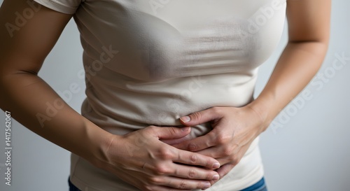 Wallpaper Mural A woman holding her stomach, indicating abdominal pain and discomfort due to an illness or ailment. Torontodigital.ca