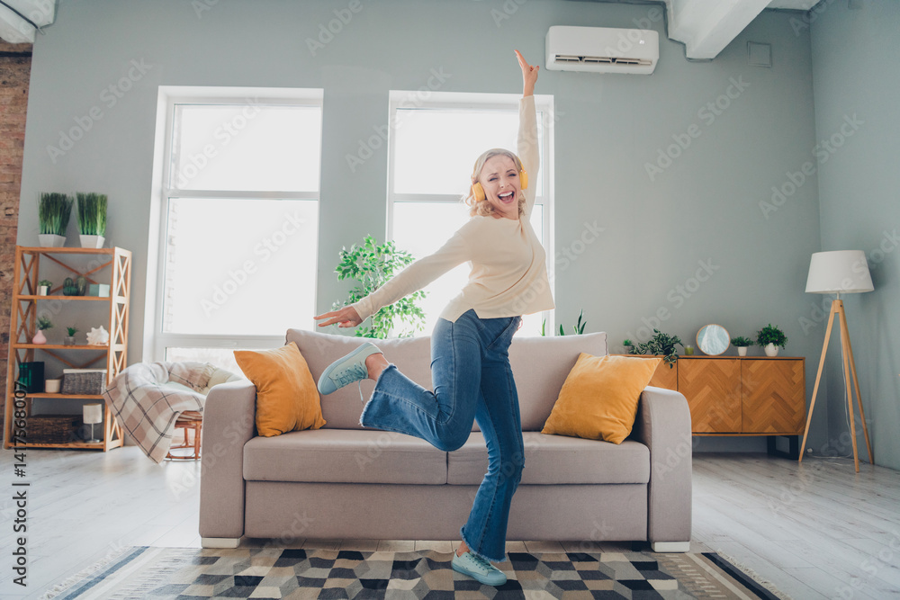 Young woman joyfully dancing in a cozy living room with modern interior design and natural daylight streaming through the windows Young woman joyfully dancing in a cozy living room with modern interior design and natural daylight streaming through the windows