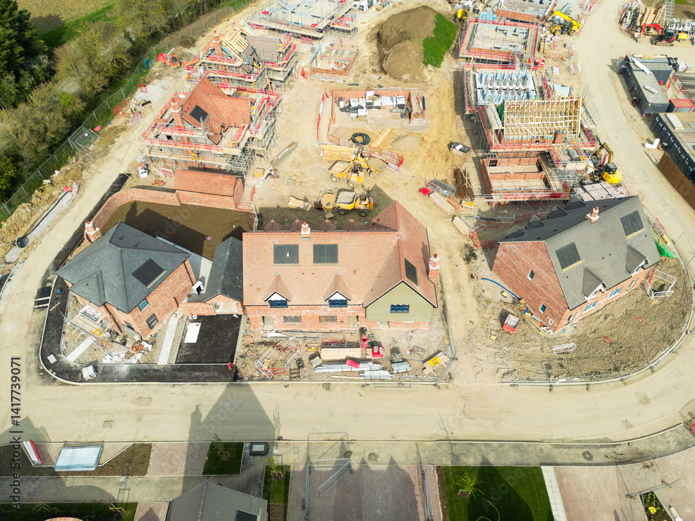 Drone view of partially and nearly completed private and affordable homes seen on a housing development site in rural England.