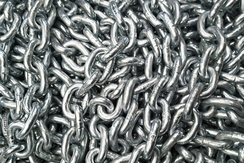 Metal chain texture. Industrial steel links. Silver iron chainpile. Strong secure material. Heavy duty construction. Durable steel pattern. Metallic connection detail. Hardware background.
