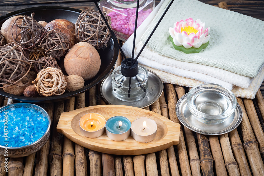Spa treatment with candles and towel on wooden table, closeup