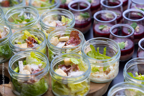 Obraz na płótnie Catering service preparing fresh caesar salad in glass jars for event w salonie