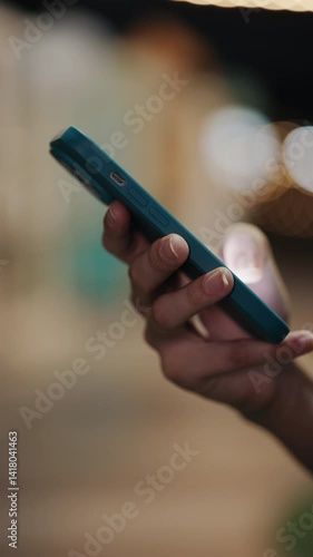 Close-Up View Of Hand Scrolling Through Smartphone, Browsing Internet. Young Woman Is Scrolling Through Social Media On Smartphone. People and Technology Concept. Vertical video