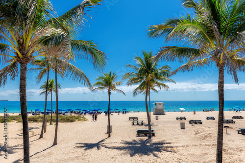 Obraz na płótnie Beautiful palm trees in tropical sunny beach and beach umbrellas in Fort Lauderdale Beach Park, Florida w salonie