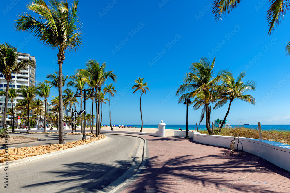 Seafront promenade and wonderful beach with palm trees on a sunny summer day in Fort Lauderdale beach, Florida