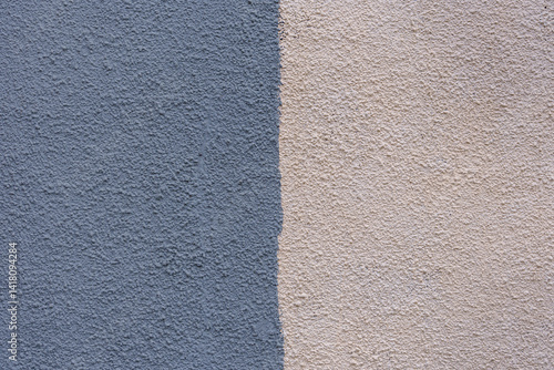 A wall with a blue and white stripe. The blue is darker than the white. The wall is made of concrete.