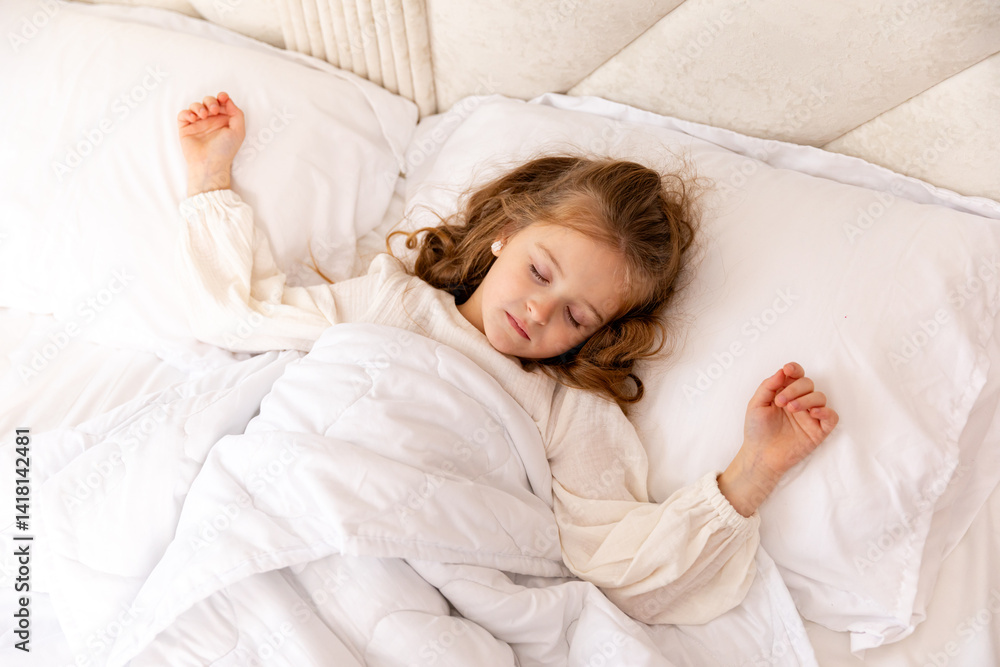 Cute little blonde girl, 6-7 years old, sleeping in bed under a white blanket, copyspace. Have a nice day. Motherhood and childcare concept. High quality photo. Top view
