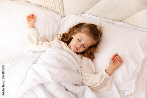 Obraz na płótnie Cute little blonde girl, 6-7 years old, sleeping in bed under a white blanket, copyspace. Have a nice day. Motherhood and childcare concept. High quality photo. Top view w salonie
