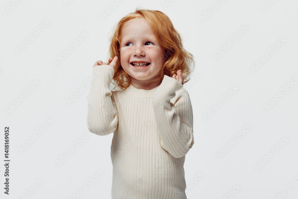 Redhaired girl posing with hands on head in front of white background for fashion and beauty concept shoot Redhaired girl posing with hands on head in front of white background for fashion and beauty concept shoot