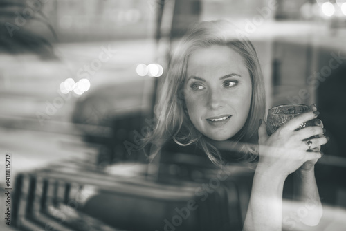 Thoughtful Woman Looking Through Window While Holding a Glass – Black and White Portrait