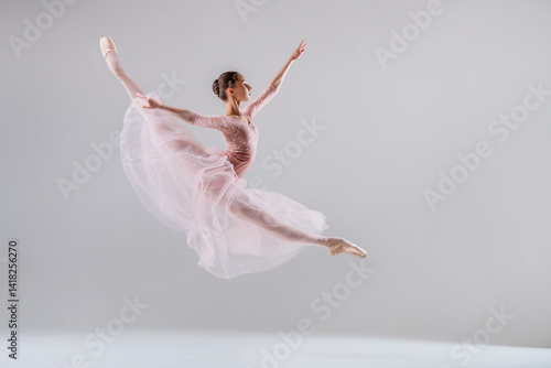 Wallpaper Mural Ballerina soaring in a split jump in a pink tutu on neutral background. Torontodigital.ca
