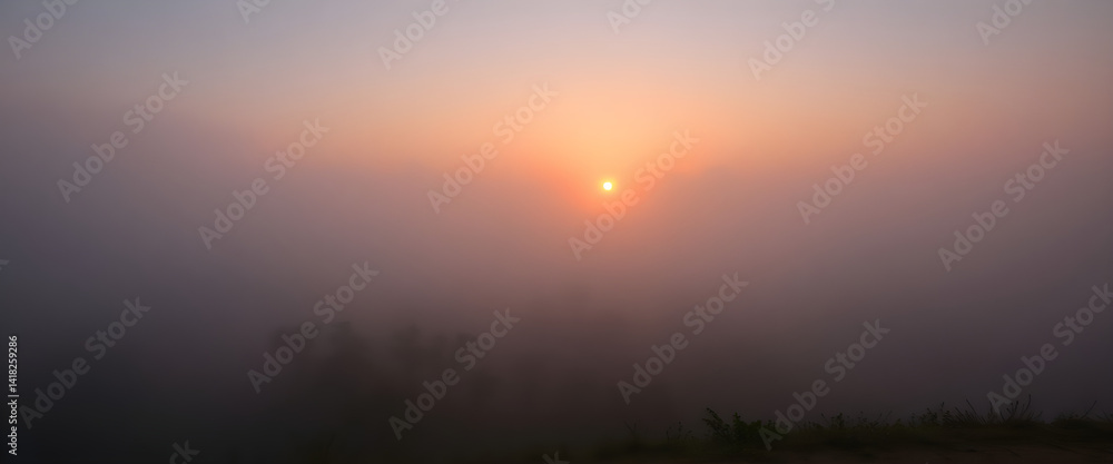 Fototapeta premium sun is setting in the foggy sky