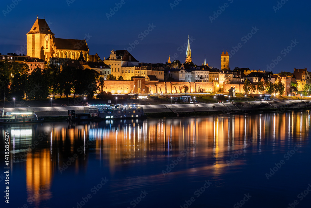 Fototapeta premium Torun old town at night reflected in the Vistula river, Poland.