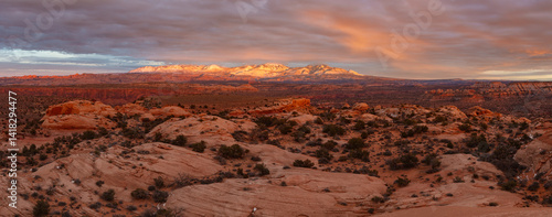 Landscape panorama featuring the La Sal Mountains rising above the rugged desert at sunset south of Moab Utah.