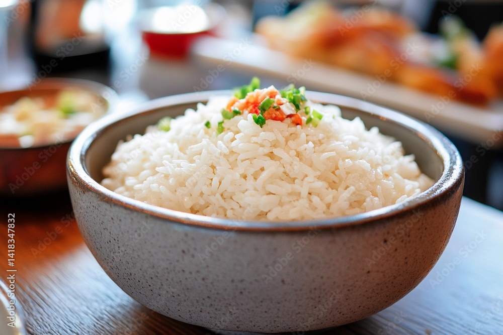 A generously portioned bowl of fluffy white rice is garnished with chopped green onions. The setting features a warm atmosphere, ideal for sharing meals with friends A generously portioned bowl of fluffy white rice is garnished with chopped green onions. The setting features a warm atmosphere, ideal for sharing meals with friends