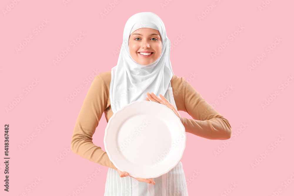 Beautiful Arabian woman with empty plate on pink background Beautiful Arabian woman with empty plate on pink background